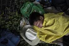 Dani descansa sobre el monte, a la orilla de la carretera, cerca de la estación migratoria del municipio de Huehuetán, durante una pausa de la caravana. Dani tiene en mente buscar asilo en México. Así como en El Salvador, no hay nadie que lo espere en Estados Unidos.