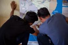 Dos jóvenes revisan la ruta que deben seguir en su camino hacia el norte en un mapa de la Casa del Migrante. Esquipulas, 1 de febrero de 2020. Foto: Martín Cálix.