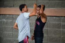 La tarde previa al día de salida de la caravana migrante, dos jóvenes se arreglan mutuamente el pelo con una gillette. San Pedro Sula, 30 de enero de 2020. Foto: Martín Cálix.