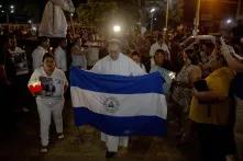 El padre Edwin Román, párroco de la Iglesia San Miguel en Masaya, cargo una bandera de Nicaragua durante la procesión del silencio que se realiza el  jueves santo. En la procesión también participaron familiares de los muertos y de los presos políticos. Debido a la labor humanitaria que Román realiza, ha recibido amenazas de muerte, es por eso que  desde junio del año pasado posee medidas cautelares por parte de la CIDH. 18 de abril de 2019. Foto: Fred Ramos