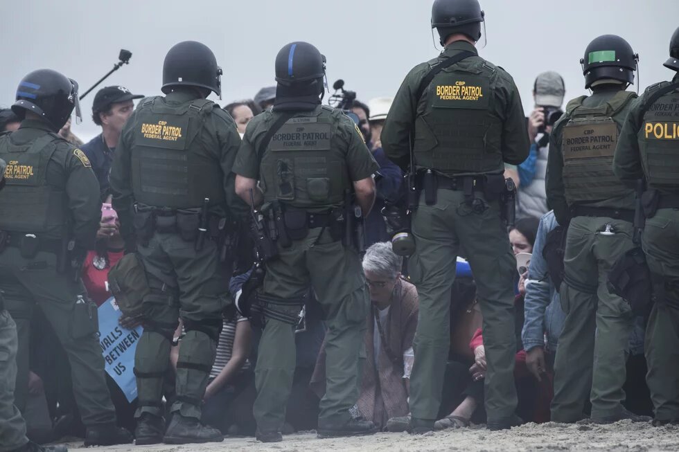 Una muralla de agentes de la Patrulla Fronteriza custodiaba la zona y bloqueó el paso de la caravana a 30 metros del muro, sobre la costa de San Diego.